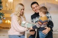 Happy mom, dad and little son give presents to each other. Enjoying love hugs, holidays people. Togetherness concept Royalty Free Stock Photo