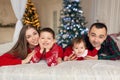 Christmas family. Happy mom,dad and little daughter and son, lying down. Enjoyng love hugs, holidays people. Togetherness concept Royalty Free Stock Photo