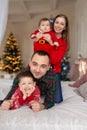 Christmas family. Happy mom,dad and little daughter and son, lying down. Enjoyng love hugs, holidays people. Togetherness concept Royalty Free Stock Photo