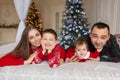 Christmas family Happy mom,dad and little daughter and son, lying down. Enjoyng love hugs, holidays people. Togetherness concept Royalty Free Stock Photo