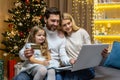 Christmas family, husband wife and little daughter for Christmas at home make online shopping in online store remotely Royalty Free Stock Photo