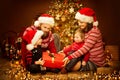 Christmas Family opening Present, Xmas Tree and Gifts, Happy Father Mother Child and Baby in Red Hat Royalty Free Stock Photo