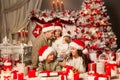 Christmas Family opening Presents. Family with Kids in Santa Hats next to Christmas Tree with White Gift Boxes. Xmas Home Room Royalty Free Stock Photo