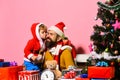 Christmas family opens presents on pink background. Royalty Free Stock Photo