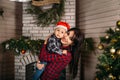 Christmas family portrait of happy smiling little boy in red santa hat in mother`s hands. Winter holiday Xmas and New Year concept Royalty Free Stock Photo