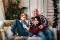 Christmas family portrait of young happy smiling parents playing with small kid in red santa hat. Winter holiday Xmas and New Year Royalty Free Stock Photo