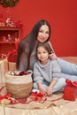 Christmas family. Red Merry Christmas tree background. Woman mother and child daughter celebrate new year. Xmas greeting card. Royalty Free Stock Photo