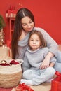 Christmas family. Red Merry Christmas tree background. Woman mother and child daughter celebrate new year. Xmas greeting card. Royalty Free Stock Photo