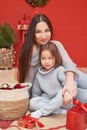 Christmas family. Red Merry Christmas tree background. Woman mother and child daughter celebrate new year. Xmas greeting card. Royalty Free Stock Photo