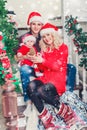 Christmas family smiling near the Xmas tree. Living room decorated by Christmas tree and present gift box Royalty Free Stock Photo