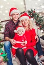 Christmas family smiling near the Xmas tree. Living room decorated by Christmas tree and present gift box Royalty Free Stock Photo