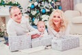 Christmas family smiling near the Xmas tree. Living room decorated by Christmas tree and present gift box Royalty Free Stock Photo