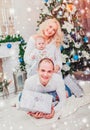 Christmas family smiling near the Xmas tree. Living room decorated by Christmas tree and present gift box Royalty Free Stock Photo