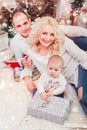 Christmas family smiling near the Xmas tree. Living room decorated by Christmas tree and present gift box Royalty Free Stock Photo