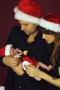 Christmas family of three persons in red hats. Happy parents and small beautiful baby Royalty Free Stock Photo