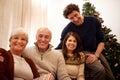 Christmas, family and visit with a man, woman and senior parents together in the living room of a home. Portrait, happy Royalty Free Stock Photo