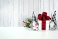 Christmas Farmhouse style background with red plaid bow gift and gnomes.