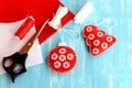 Christmas felt red ball and tree, scissors, white and red threads, needle, cord on blue wooden background Royalty Free Stock Photo