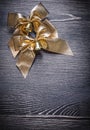 Christmas festal golden bows on wooden board Royalty Free Stock Photo