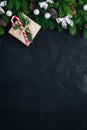 Christmas festive background with christmas tree branches, fir cones and gift box with candy cane on dark concrete stone Royalty Free Stock Photo