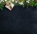 Christmas festive background with christmas tree branches, fir cones and gift box with candy cane on dark concrete stone Royalty Free Stock Photo