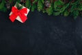 Christmas festive background with christmas tree branches, fir cones and gift box on dark concrete stone background Royalty Free Stock Photo