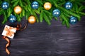 Christmas festive border, New Year decorative frame, golden and blue balls decorations on green fir branches, gift box on black Royalty Free Stock Photo