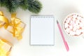 Christmas festive composition. White notepad, pink pen, gifts with a gold bow on a light table. Flat lay, top view Royalty Free Stock Photo