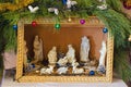 Christmas festive nativity scene made of plywood with white ceramic figures under the Christmas tree