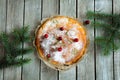Christmas festive round cake, homemade, decorated with spruce branches, on a gray background. Top view, daylight