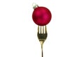 Christmas festive table. Gold fork and red Xmas bauble on white