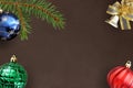 Christmas fir branch, blue, green ribbed and red wavy balloon and decorative bell on dark