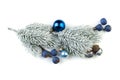 Christmas fir branch with silver baubles, blue berries and other ornaments isolated on white Royalty Free Stock Photo