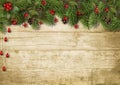 Christmas fir branches and holly on wood background Royalty Free Stock Photo