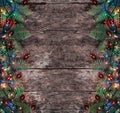 Christmas Fir branches with lights and red decorations on wooden background. Xmas and Happy New Year composition
