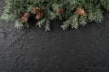 Christmas Fir branches with pine cones on dark black background. Xmas and Happy New Year card, bokeh, sparking, glowing Royalty Free Stock Photo