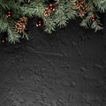 Christmas Fir branches with pine cones on dark black background. Xmas and Happy New Year card, bokeh, sparking, glowing. Royalty Free Stock Photo