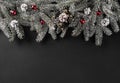 Christmas fir branches with pine cones, red decoration on dark background Royalty Free Stock Photo