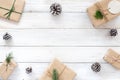 Christmas fir leaves, pine cones and gift on white rustic wooden background.