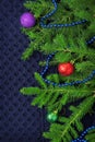 Christmas fir tree with decoration on dark blue knitted wool background Royalty Free Stock Photo