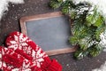 Christmas fir tree, mittens and chalkboard for your greetings Royalty Free Stock Photo