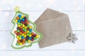 Christmas fir-tree plate with colorful candies and an envelope for wishes Royalty Free Stock Photo