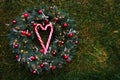 Christmas fir wreath with decor and candycanes on a background of grass