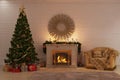 Christmas fire near a Christmas tree with gifts and a cozy armchair