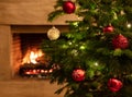 Christmas tree close up on burning fireplace background Royalty Free Stock Photo