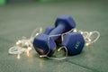 Christmas fitness composition with blue dumbbells, gift on white background with bokeh and show. Greeting