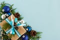 Christmas flat lay composition of fir branches with gift box and decorations with copy space on the blue background. Royalty Free Stock Photo
