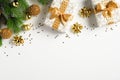 Christmas flat lay composition. Top view gold pine tree branch, Xmas decorations, golden balls and gift boxes on white background