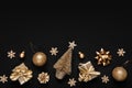 Christmas flat lay of decorations in golden monochrome tones on black background