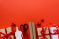 Christmas flat lay of gift boxes with wrapping craft paper, scissors, glue and decorations